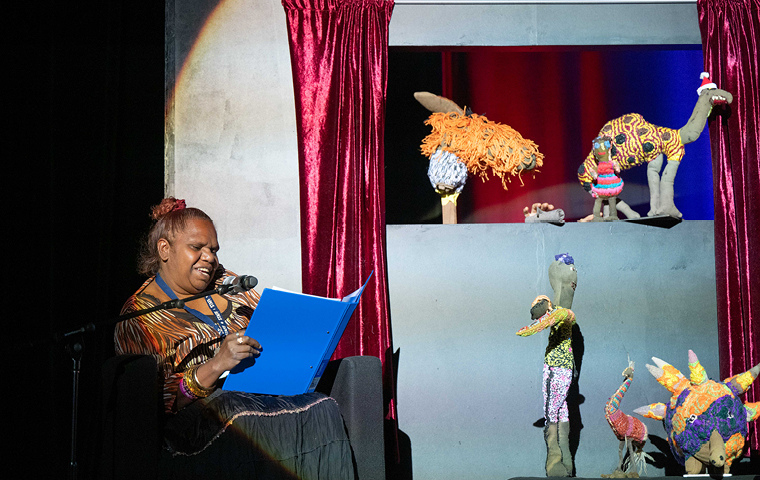 1.  Louise Robertson narrating the Yarrenyty Arltere Artists puppet show, at the Desert Mob Artist Talks, 2024. Photo by Sara Ma