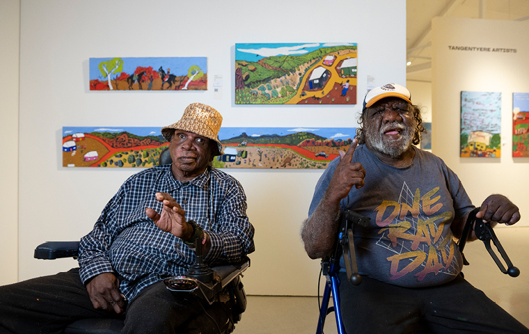 3. L-R Adrian Jangala Robertson and Billy Kenda of Bindi Mwerre Anthurre Artists in front of their art centre's works at Desert 